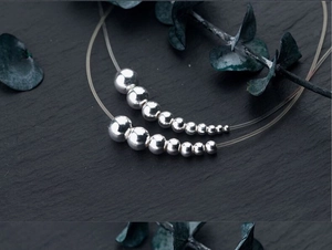 Macro shot of S925 sterling silver large hole beads in various sizes on dark stone