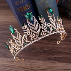 Baroque gold queen crown with green teardrop rhinestones on vintage books
