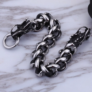 Silver and black stainless steel dragon head bracelet for men on grey marble surface