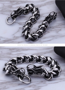 Detail of silver dragon head bracelet with thick Cuban chain and textured metal scales