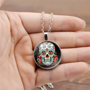 Detailed close-up of sugar skull glass dome pendant necklace with silver chain link