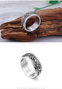 Detailed view of vintage titanium steel ring with gothic floral engraving on wood base
