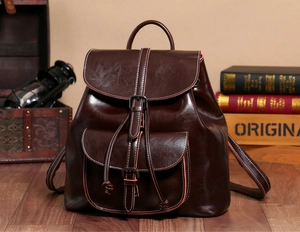 Close-up of retro dark brown oil wax leather backpack with metal buckle and vintage decor