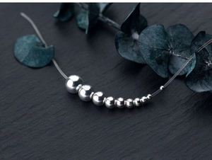 Macro shot of polished S925 sterling silver loose beads ranging from 3mm to 10mm sizes