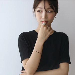 Close-up of minimalist brushed silver ring and bracelet set worn by a fashion model
