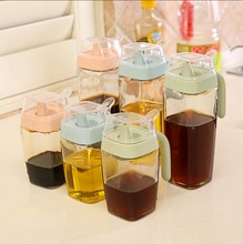 Close-up of glass condiment bottles with colorful plastic lids for oil and soy sauce storage