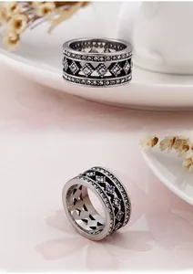 Detail of silver bohemian wide ring with hollow geometric patterns and white zircon