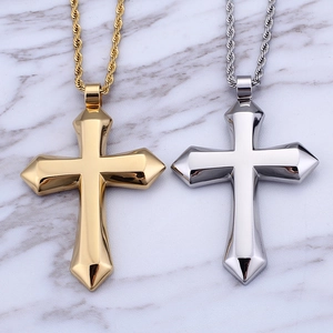Polished gold and silver stainless steel cross necklaces with twisted chains on marble