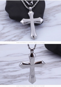 Macro view of polished silver stainless steel cross pendant on marble background
