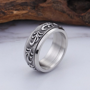 Vintage men's titanium steel ring with silver vine patterns on a rustic wood background