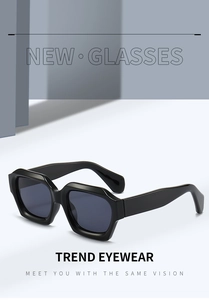 Detailed close-up of chunky black irregular hexagonal sunglasses on a minimalist background