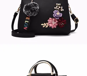 Detail view of black lychee leather bag with 3D floral embroidery and pearl accents