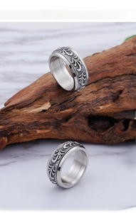Detail of silver vintage spinning ring with engraved filigree patterns in titanium steel