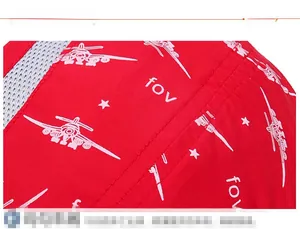 Detail of red quick-dry cap showing white airplane print and breathable grey mesh fabric