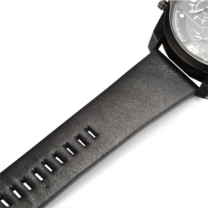 Gros plan du bracelet de montre en cuir noir grainé et du boîtier en acier noir mat