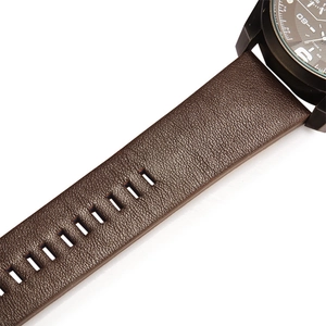 Vue détaillée du bracelet en cuir marron texturé et du boîtier en métal noir mat