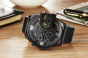 Gros plan de la montre Oulm avec boussole sur bureau en bois et carnet en cuir