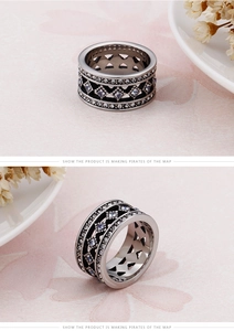 Detail view of silver stainless steel vintage ring with blue gems and intricate engravings