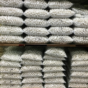Bulk pack of 10mm and 12mm cream white ABS pearls stored in clear warehouse bags