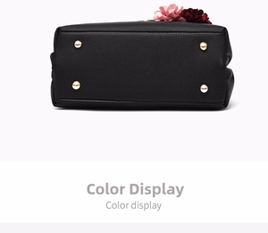 Detail view of black lychee grain leather bag base with four golden metal protective feet