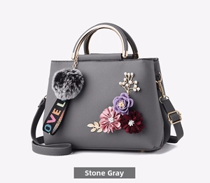 Detail of marble gray faux leather handbag with 3D floral accents and pearl ornaments