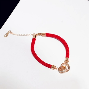 Detail of red string bracelet with rose gold double rings and roman numerals