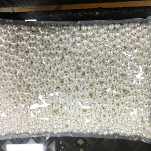 Macro view of loose white ABS imitation pearls in a wholesale bulk package