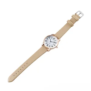 Close-up of gold quartz watch with white dial, Arabic numerals and champagne shiny strap