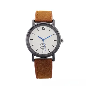 Detail of quartz watch with brown suede strap, black matte case and blue hands on white dial