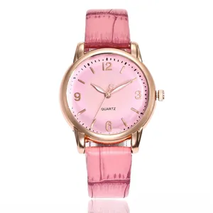 Detail of pink faux leather strap and rose gold case on a women quartz wristwatch
