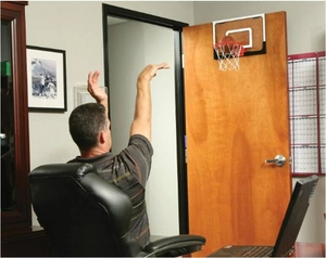 Actiefoto van een mini-basketbalring aan een kantoordeur met een zachte schuimbal