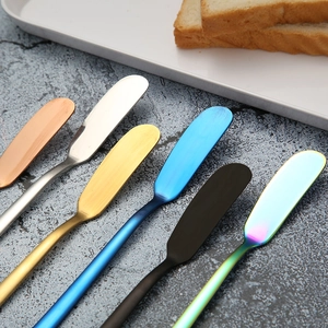 Set of 6 colorful stainless steel butter spreaders with long handles on a grey surface