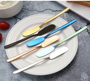 Detailed overhead view of 6 colorful stainless steel butter knives on a white plate