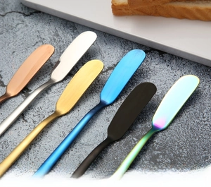 Detail view of colorful 304 stainless steel butter knives set on a dark textured surface