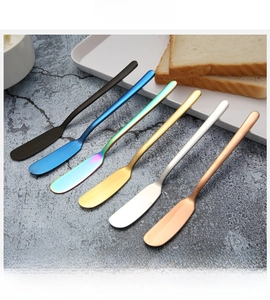Set of six colorful 304 stainless steel butter knives on a textured blue stone surface