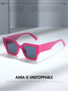 Détail de lunettes de soleil carrées rose vif tendance avec verres gris foncé et éclairage pro