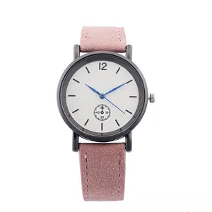 Close-up of minimalist black quartz watch with pink leather strap and blue hands