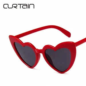 Trendy red heart-shaped sunglasses with dark grey lenses on a clean white background