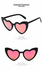 Detail view of heart-shaped sunglasses with black frames and pink mirrored lenses