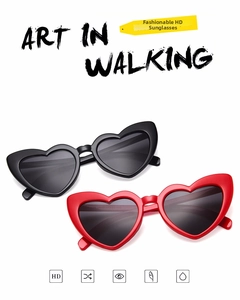 Flat lay of heart-shaped sunglasses in black and red glossy frames for women