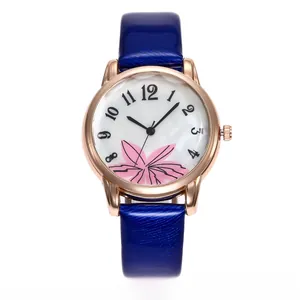 Detail of rose gold watch with blue floral printed leather strap and mother of pearl dial