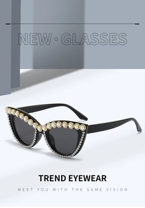 Macro detail of cat eye sunglasses with rhinestones and pearl embellishments on the frame