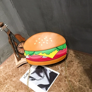 Creative hamburger shaped crossbody bag with gold chain strap on a stone surface