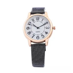 Detail of rose gold quartz watch with white dial and large black Arabic numerals