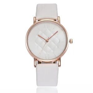 Close-up of elegant rose gold watch featuring a white quilted dial and slim leather strap