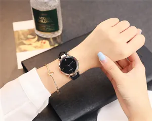 Gros plan d'une élégante montre à quartz pour femme avec cadran noir facetté et bracelet cuir