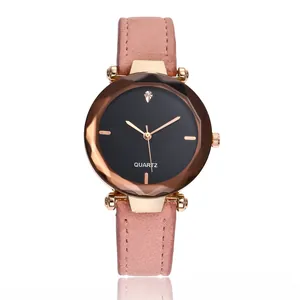 Détail d'une montre en or rose avec bracelet en cuir rose et verre facetté