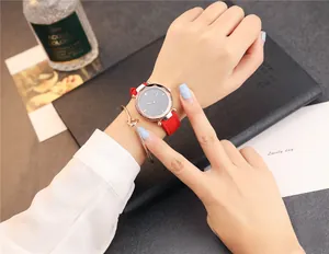 Gros plan d'une montre à quartz avec bracelet en cuir rouge et lunette en or rose