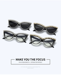 Detail of luxury cat-eye frames with sparkling rhinestones and pearl flower embellishments