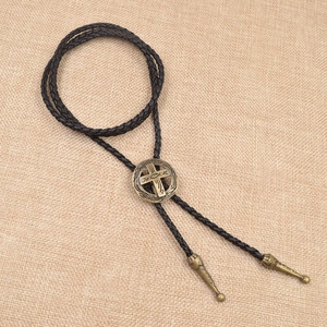 Detail einer Vintage-Bolo-Krawatte mit bronzener Metallschnalle an schwarzer Lederschnur